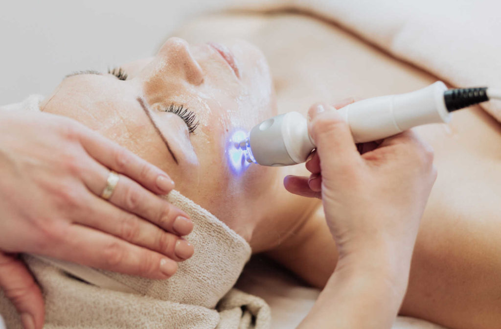 An aesthetician performing Co2 laser treatment to treat a woman for rhinophyma at our dermatology in calgary.